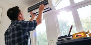 Technician installing air conditioning unit in a home.